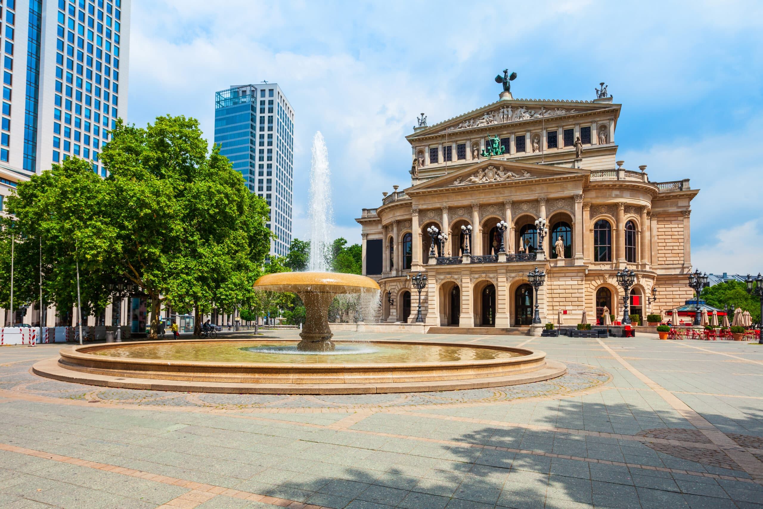 Opernhaus in Frontalperspektive mit neoklassizistischer Sandsteinfassade Arkaden und Brunnen
