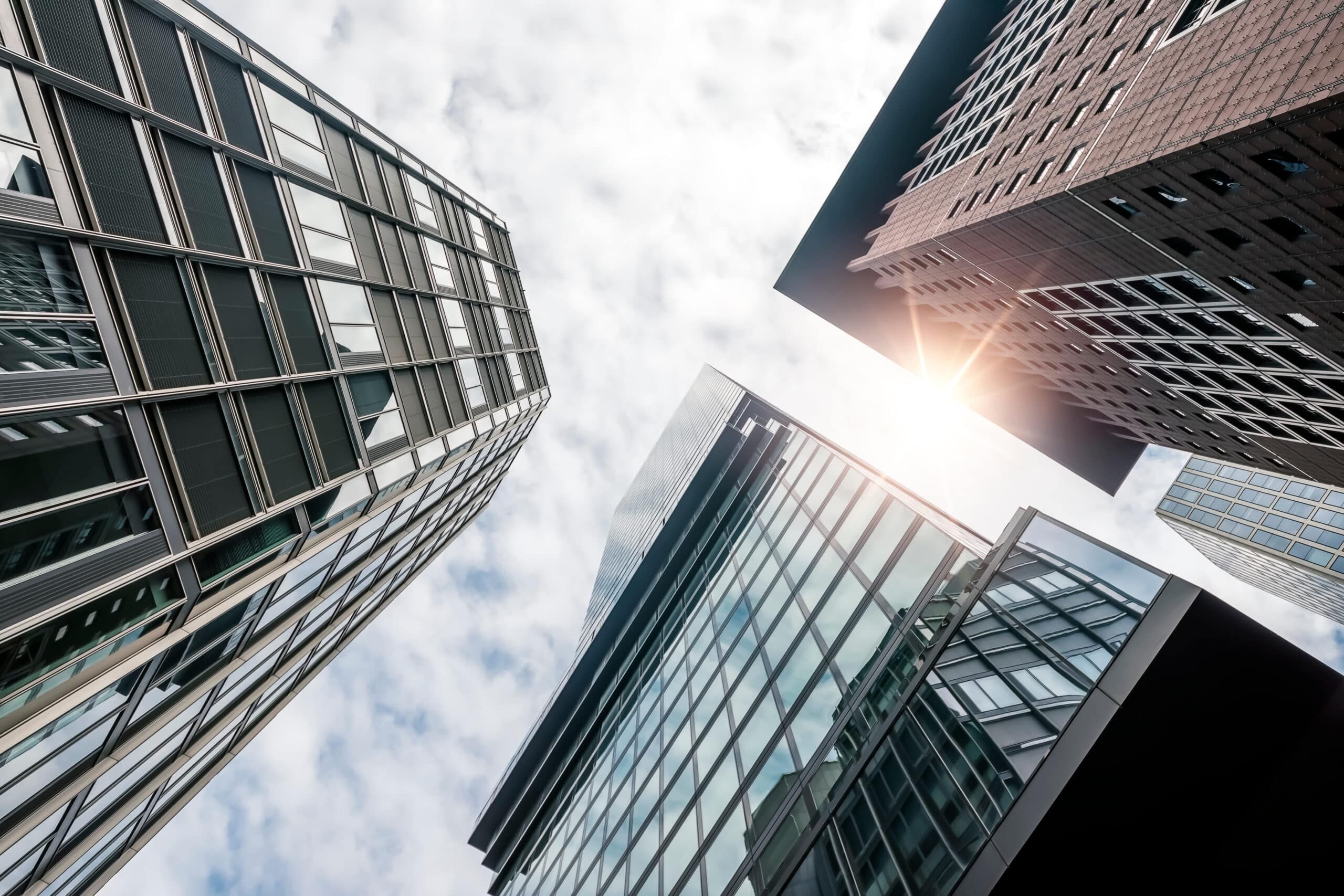 Vier Hochhäuser aus Froschperspektive mit gläsernen Fassaden und brauner Klinkerfassade