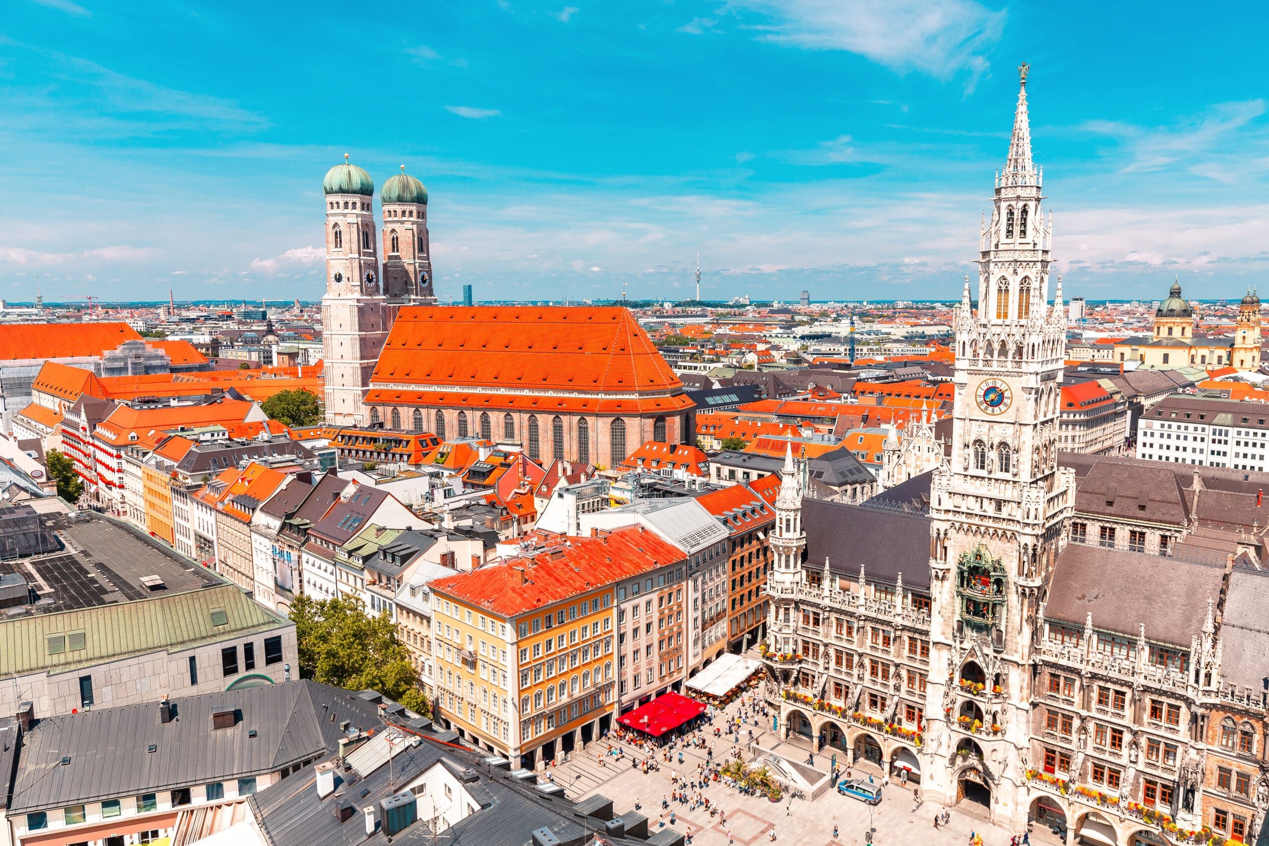Vogelperspektive auf neugotisches Rathausgebäude am belebten Marktplatz mit Turm und roten Dächern